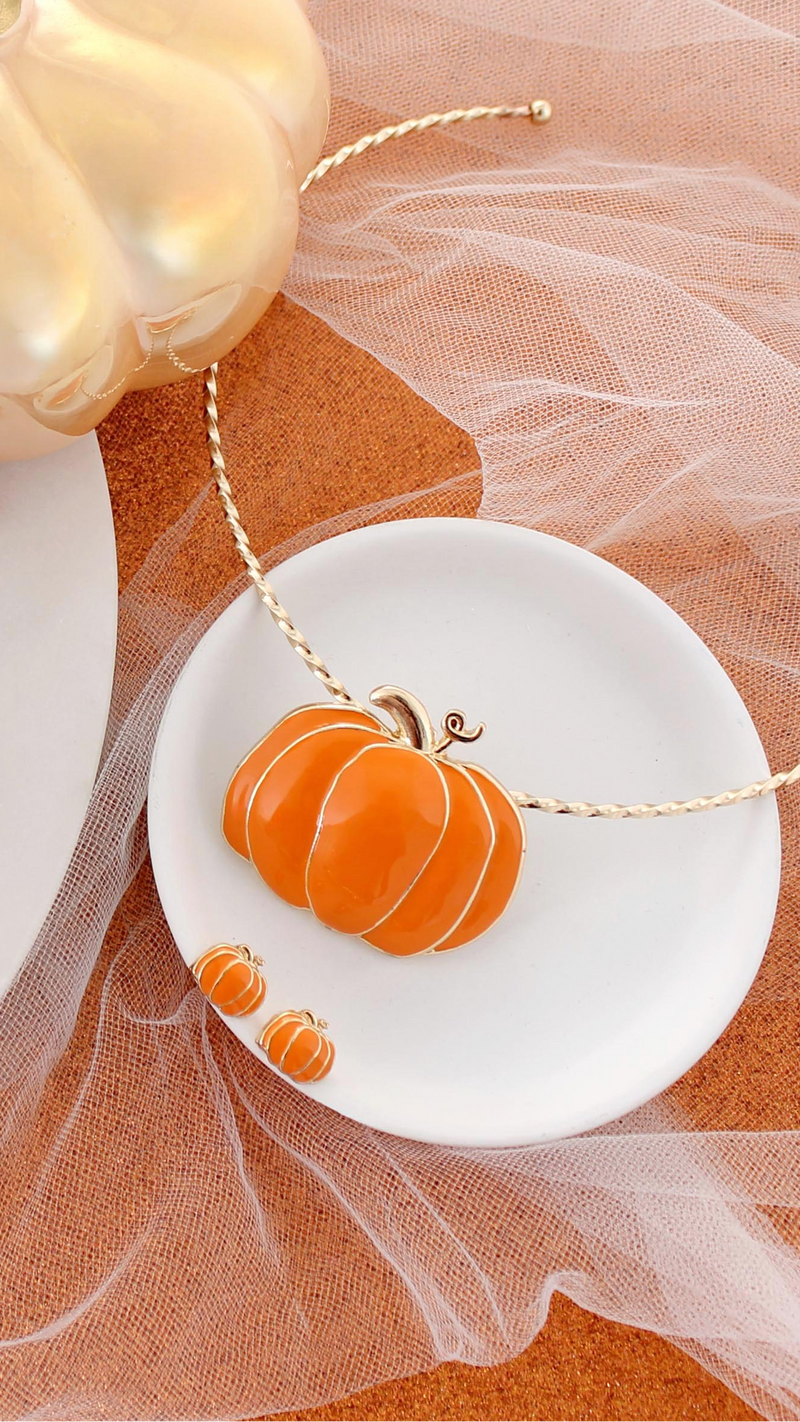 Halloween-themed jewelry set with pumpkin design on a white and orange fabric background